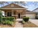 Charming home exterior featuring a cozy front porch, brick driveway, and landscaped garden at 11619 Chateaubriand Ave, Orlando, FL 32836