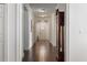 Hallway with hardwood flooring, leading to the entrance, adorned with a grandfather clock at 11619 Chateaubriand Ave, Orlando, FL 32836