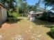 Spacious backyard with a small wooden deck, decorative wishing well, and mature trees at 12314 Virginia Dr, Leesburg, FL 34788