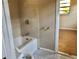 Bathroom with tiled shower, tiled floor, and commode at 12314 Virginia Dr, Leesburg, FL 34788