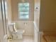 Bathroom with a toilet, tiled floors, and wainscotting at 12314 Virginia Dr, Leesburg, FL 34788