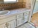 Bathroom vanity with neutral tile counter and white cabinet doors at 12314 Virginia Dr, Leesburg, FL 34788