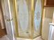 Bathroom shower with decorative glass doors and gold trim at 12314 Virginia Dr, Leesburg, FL 34788