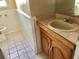 Bathroom with a single sink vanity, a tile floor, and a toilet at 12314 Virginia Dr, Leesburg, FL 34788