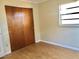 Simple bedroom featuring laminate flooring, a window, and a standard closet at 12314 Virginia Dr, Leesburg, FL 34788