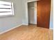 Bright bedroom with light walls, wood floor, and closet with sliding doors at 12314 Virginia Dr, Leesburg, FL 34788