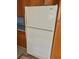 Close-up of a standard white refrigerator with wood cabinets, in a kitchen at 12314 Virginia Dr, Leesburg, FL 34788