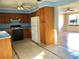 Bright kitchen with light wood cabinets, standard appliances, and tiled floors open to living area at 12314 Virginia Dr, Leesburg, FL 34788