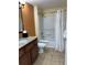 Bathroom showcasing a vanity, toilet, shower and tub combination with neutral tile at 12521 Floridays Resort Dr # 206F, Orlando, FL 32821