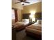 Cozy bedroom with two beds, bedside table, and a window with curtains at 12521 Floridays Resort Dr # 206F, Orlando, FL 32821