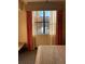 Bedroom window view with patterned curtains overlooking trees and a fountain at 12521 Floridays Resort Dr # 206F, Orlando, FL 32821