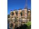 Waterfront condominium building featuring multi-story balconies and lush landscaping at 12521 Floridays Resort Dr # 206F, Orlando, FL 32821