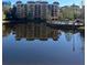 View of a condominium building with a pool and a pond on a sunny day at 12521 Floridays Resort Dr # 206F, Orlando, FL 32821