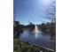 A community pond features a water fountain and is bordered by trees and landscaping at 12521 Floridays Resort Dr # 206F, Orlando, FL 32821