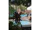 A community swimming pool and hot tub are surrounded by tropical foliage and lounge chairs at 12521 Floridays Resort Dr # 206F, Orlando, FL 32821