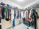 Walk-in closet with metal shelving racks and rods, filled with clothes, shoes, luggage, and personal items at 13730 Bravante Aly, Windermere, FL 34786