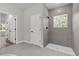 Bright bathroom featuring a tiled shower with window and a white door leading to the rest of the home at 13817 Sw 43Rd Cir, Ocala, FL 34473