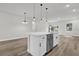 Kitchen island with white cabinets, quartz countertop, stainless steel dishwasher, and pendant lights at 13817 Sw 43Rd Cir, Ocala, FL 34473