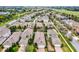 Aerial shot of a lovely home with a well-maintained lawn, mature trees, and nice landscaping near a peaceful lake at 15506 Tidal Cove Aly, Winter Garden, FL 34787