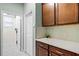 Pantry with wood cabinets and a quartz countertop, positioned next to a laundry room entrance at 15506 Tidal Cove Aly, Winter Garden, FL 34787