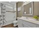 Well-lit bathroom with modern fixtures, a shower, and a vanity with white countertops at 16259 Misty Hills Ave, Winter Garden, FL 34787