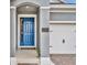 Exterior of home featuring a blue front door and a partial view of the garage at 16259 Misty Hills Ave, Winter Garden, FL 34787