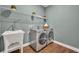 Well-appointed laundry room featuring modern washer and dryer, utility sink, and shelving at 16259 Misty Hills Ave, Winter Garden, FL 34787