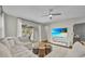 Bright living room with a ceiling fan, plush sofa, and sliding glass doors leading to an outdoor patio at 16259 Misty Hills Ave, Winter Garden, FL 34787