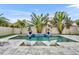 Backyard pool area with water feature, lush palms, and stylish in-pool lounge chairs at 16259 Misty Hills Ave, Winter Garden, FL 34787