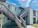 A close up of exterior stairs leading to apartments with a wooden railing at 166 Scottsdale Sq # 166, Winter Park, FL 32792