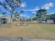 View from porch featuring a playground and lush green common area with mature trees at 166 Scottsdale Sq # 166, Winter Park, FL 32792