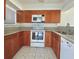 Kitchen featuring wood cabinets, granite countertops, and white appliances at 166 Scottsdale Sq # 166, Winter Park, FL 32792