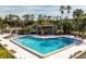 Community pool with lounge chairs and tropical landscaping at 166 Scottsdale Sq # 166, Winter Park, FL 32792