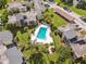 Aerial view of a community pool surrounded by townhomes and lush landscaping with covered parking in the distance at 166 Scottsdale Sq # 166, Winter Park, FL 32792