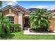 Close-up of a home's front entrance featuring a well-kept lawn and lush landscaping at 2281 The Oaks Blvd, Kissimmee, FL 34746