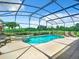 Sparkling pool with spa surrounded by lush landscaping in a screened enclosure at 2281 The Oaks Blvd, Kissimmee, FL 34746