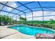 Sparkling pool and spa in a screened enclosure with lush landscaping at 2281 The Oaks Blvd, Kissimmee, FL 34746