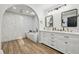 Bathroom featuring freestanding tub, double vanity with framed mirrors, wood-look tile and stylish fixtures at 2294 Lakeview Ave, Clermont, FL 34711