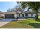 Charming single-story home featuring a well-maintained lawn, a two-car garage, and a modern front door at 2294 Lakeview Ave, Clermont, FL 34711