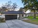 Charming home featuring a two-car garage, manicured lawn, and a welcoming walkway leading to the front door at 2294 Lakeview Ave, Clermont, FL 34711