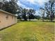 Expansive backyard featuring green grass and mature trees offering space and nature at 231 Cranbrook Dr, Kissimmee, FL 34758