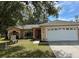 Charming single-story home featuring a well-maintained lawn and an attached two-car garage at 231 Cranbrook Dr, Kissimmee, FL 34758