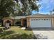 Charming single-story home featuring a well-maintained lawn and an attached two-car garage at 231 Cranbrook Dr, Kissimmee, FL 34758