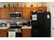 Cozy kitchen featuring wooden cabinets, stainless steel appliances, and a black refrigerator at 231 Cranbrook Dr, Kissimmee, FL 34758