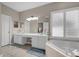 This bathroom features white cabinets, a large mirror, and a soaking tub at 2362 Blossomwood Dr, Oviedo, FL 32765