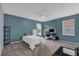 This bedroom features a blue accent wall, neutral carpet, a ceiling fan, and windows for natural light at 2362 Blossomwood Dr, Oviedo, FL 32765