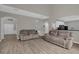 Open-concept living room with neutral walls and flooring leading to the kitchen and hallway at 2362 Blossomwood Dr, Oviedo, FL 32765