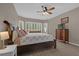 Cozy main bedroom features a ceiling fan, large windows with shutters, and wood floors at 2362 Blossomwood Dr, Oviedo, FL 32765