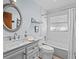 Bathroom featuring a vanity with a marble countertop, subway tile shower, and a decorative oval mirror at 2405 Janet St, Kissimmee, FL 34741