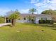 Charming single-story home featuring a well-manicured lawn and welcoming front entrance with rocking chairs at 2405 Janet St, Kissimmee, FL 34741